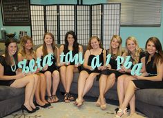 a group of women sitting on top of a couch holding up letters that spell out love