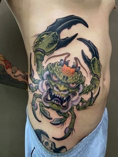 a man with tattoos on his stomach has a crab tattoo on the side of his body