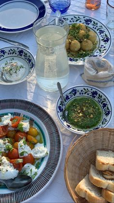 a table topped with plates and bowls filled with food