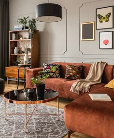 a living room filled with lots of furniture and pictures on the wall above it's coffee table