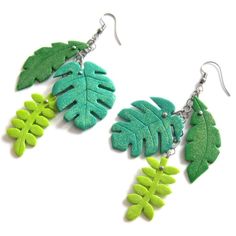 two green leaves are hanging from earrings