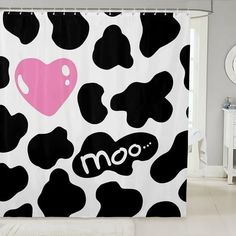 a black and white cow print shower curtain with the word moo written on it