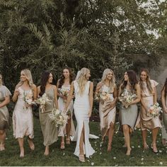 a group of women standing next to each other on top of a lush green field