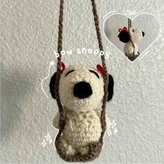 a crocheted stuffed dog hanging from a rope with a heart shaped ornament attached to it