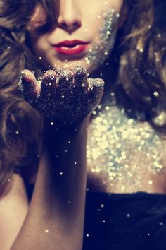 a woman with glitter on her face and hands