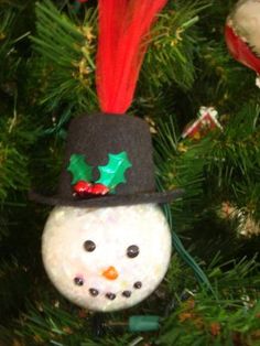 a snowman ornament hanging from a christmas tree