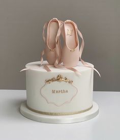 there is a white cake with pink shoes on the top and gold trimmings