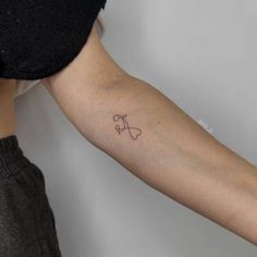 a woman's arm with a small tattoo on the left side of her arm