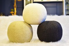 three balls sitting on top of a white fur covered floor