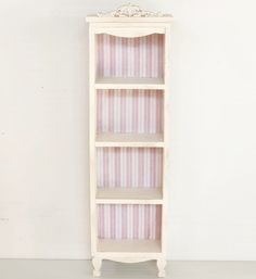 a tall white shelf with pink and white stripes