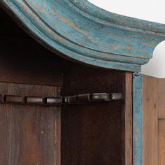 an old wooden cabinet with blue paint on the top and bottom panel, has a metal latch