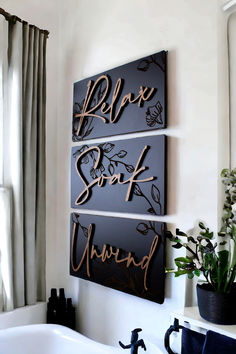 three metal wall art pieces hanging above a bathtub