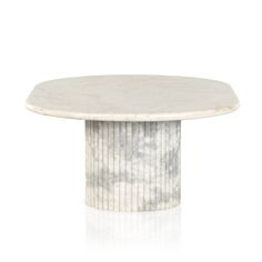 a white marble table with an oval base