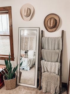 a mirror sitting on top of a wooden floor next to a chair and potted plant