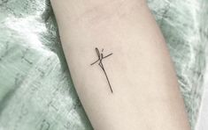 a small tattoo on the arm of a person with a cross in it's middle