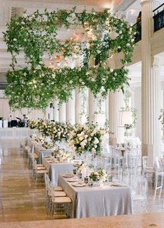 the tables are covered with white flowers and greenery