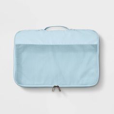 an empty blue suitcase sitting on top of a white wall with the handle down and it's zipper open