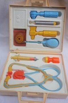 an open box with various items in it on a white surface, including scissors and hoses