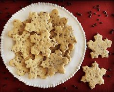 a white plate topped with cookies on top of a red table cloth next to coffee beans