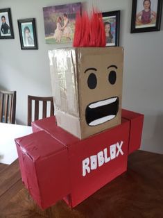 a cardboard box shaped like a robot with red hair on it's head sitting on top of a table