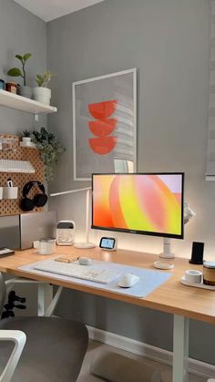 a desk with a computer monitor, keyboard and mouse on it in front of some shelves