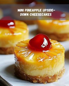 mini pineapple upside - down cheesecakes on a white plate with a cherry on top