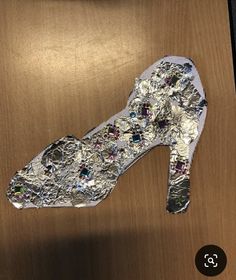 a pair of shoes that are sitting on top of a wooden table, covered in silver and multicolored jewels