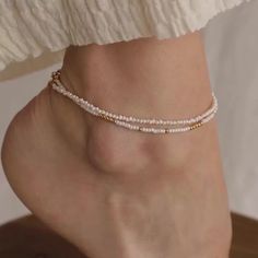 Get ready to dance with joy wearing our Dainty Pearl Beaded Anklet. This playful accessory, embellished with tiny pearls, brings a sprinkle of magic and whimsy to your summer adventures. Whether you’re wandering along sandy shores or twirling in a boho garden, this anklet adds a touch of fairy-tale charm to your ensemble. Material: High Quality Solid 925 Sterling Silver Finish: Sterling Silver ∙ 18K Gold Featuring ~2mm White & Gold or White & Silver Beads across the anklet. Anklet length is adju Gold Beaded Anklet, Delicate Pearl Chain Anklets, Gold Dainty Anklets With Pearl Charm, Adjustable Dainty Pearl Anklets, Adjustable White Pearl Anklets, Initial Tag Necklace, Pearl Anklet, Beaded Anklet, Boho Garden