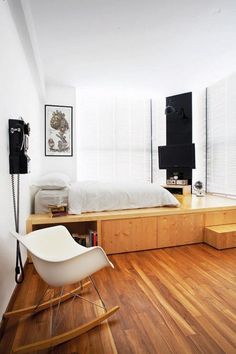 a bedroom with wooden floors and white walls