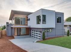 a modern house with two garages on the front and one story home in the back