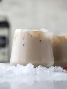 two drinks sitting on top of a table covered in snow