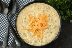 a bowl filled with cheese on top of a table next to spoons and parsley