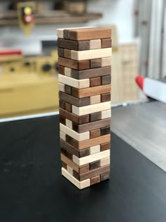 a wooden block tower sitting on top of a black table in front of a workbench