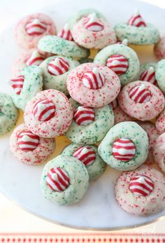 a white plate topped with green and red sprinkle covered donuts