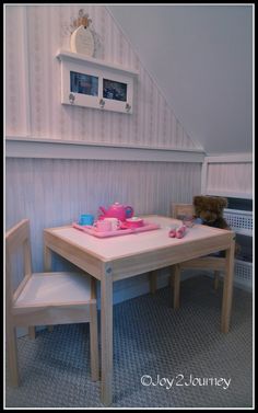 a child's table and two chairs in a room