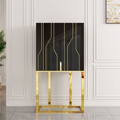 a black and gold console table in an elegant room with white walls, marble flooring and art work on the wall