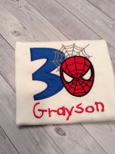 a spiderman birthday shirt with the number 3 on it and his name is grayson