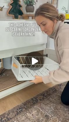 a woman is opening the dishwasher door to check out her new kitchen cabinet