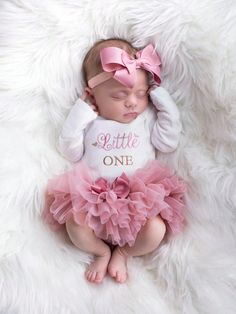 a baby girl wearing a pink and white outfit