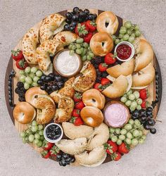 a wooden platter filled with assorted pastries and fruit