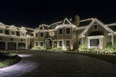 a large house with christmas lights on the front and side of it's windows