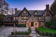 a large brick house with lots of windows and stone steps leading up to the front door