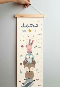 a child's growth chart with animals and stars on it, hanging from the wall