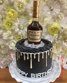 a birthday cake with a bottle of liquor on top