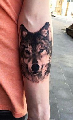 a man with a wolf tattoo on his arm