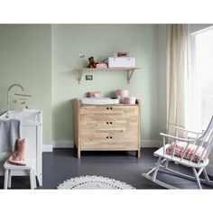 a baby's room with green walls and furniture