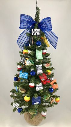 a small christmas tree with blue ribbon and ornaments