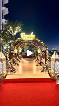 a red carpeted walkway leading up to an outdoor ceremony area with white and gold decorations