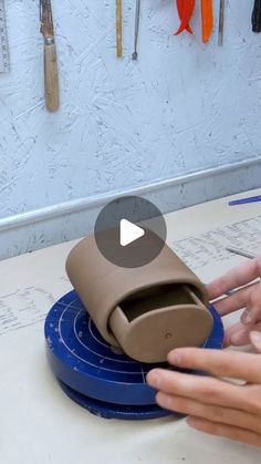 two hands are working on an object in the process of making something out of cardboard