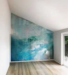 an empty room with wood floors and a large painting on the wall